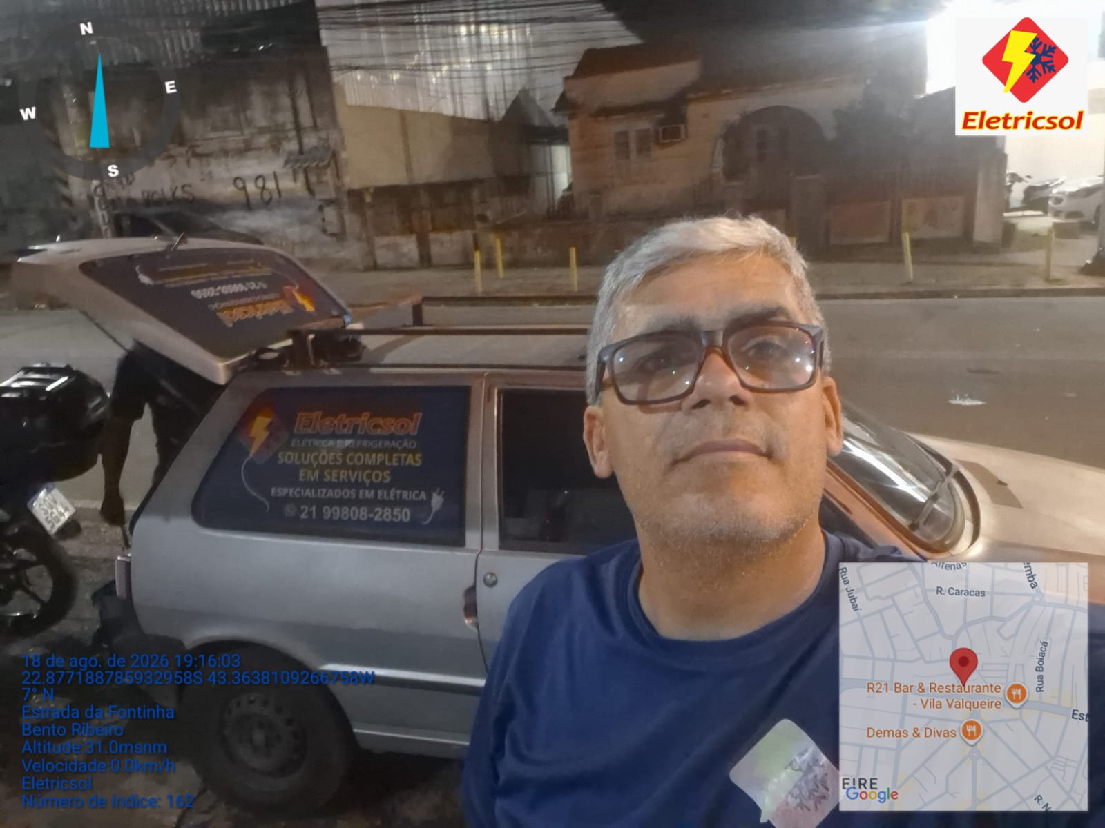 homem de óculos fazendo selfie em frente a uma van prateada com a logomarca da empresa Eletricsol, à noite, nu